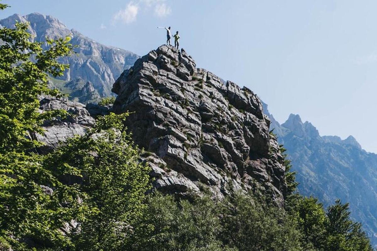 dos personas de pie en la cima de una montaña