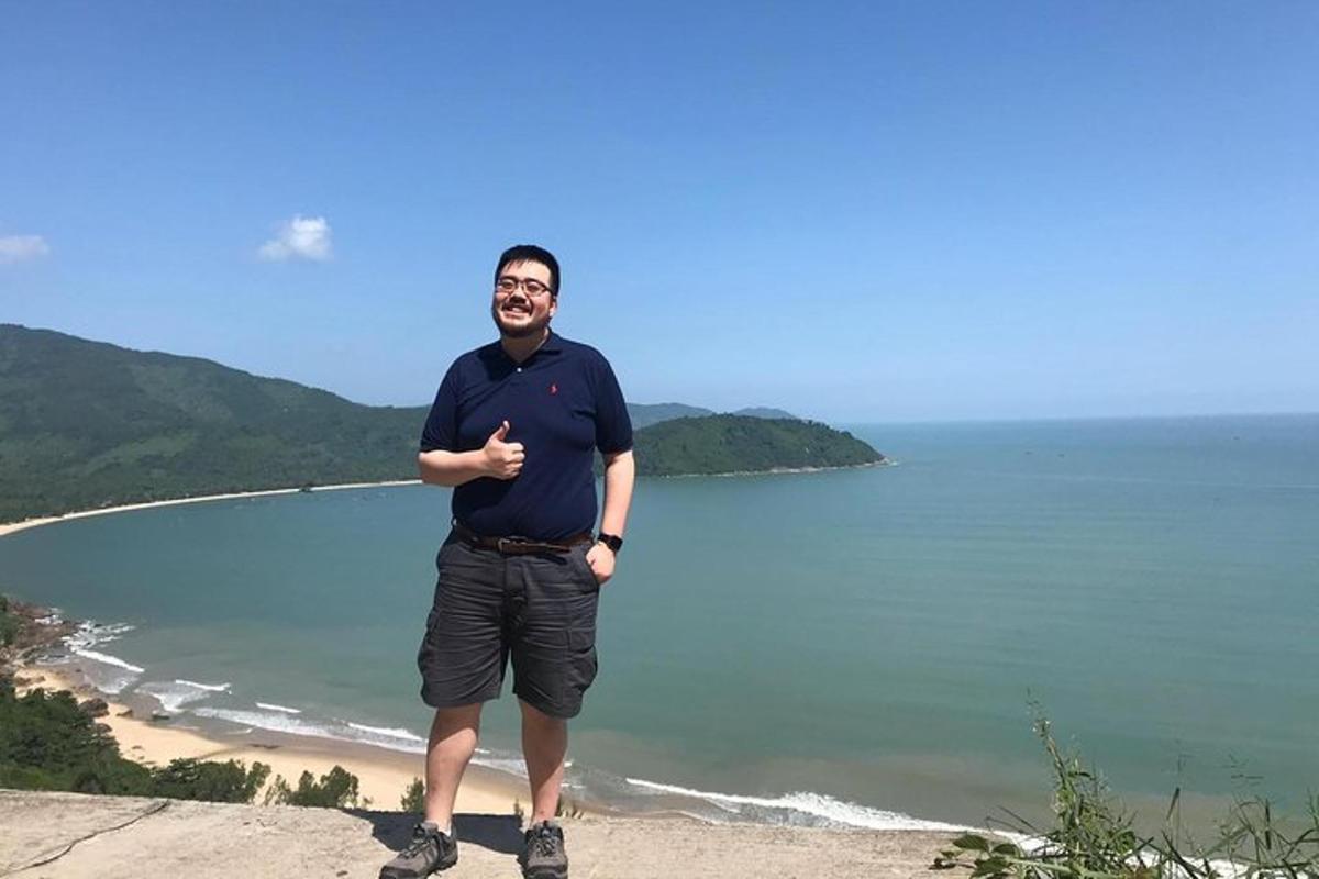 moški, ki stoji na vrhu pečine blizu oceana