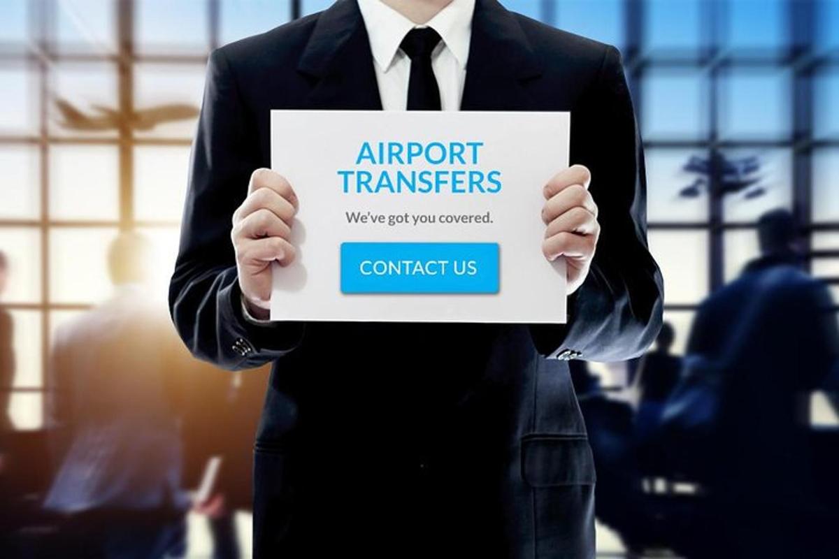 muž v obleku držící ceduli s nápisem „letištní transfery“