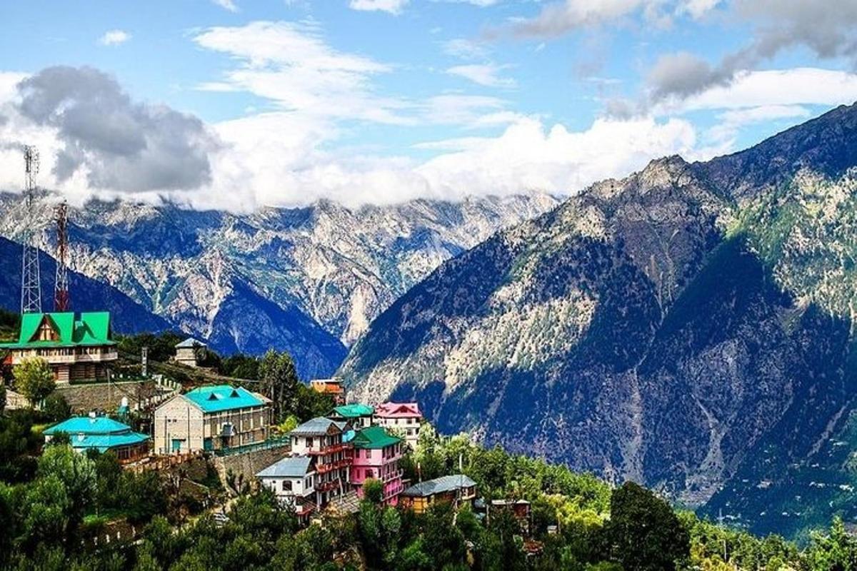 a village on a hill with mountains in the background