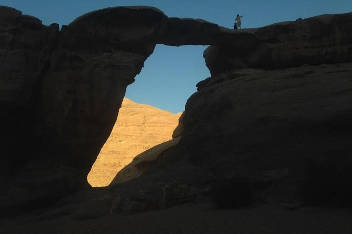 a person standing in an arch in a rock formation