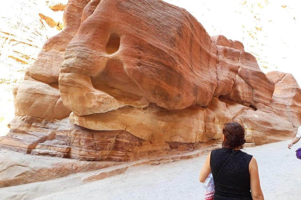 a woman standing in front of a rock formation