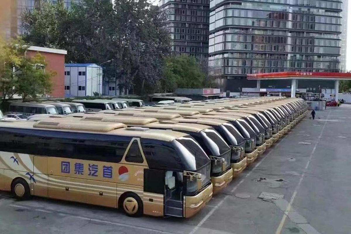 a row of buses parked in a parking lot