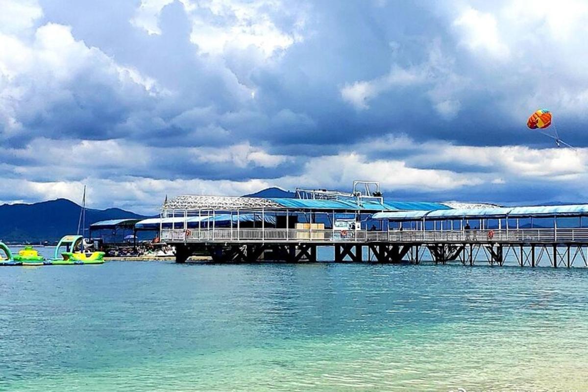 a pier on the water with a kite in the sky