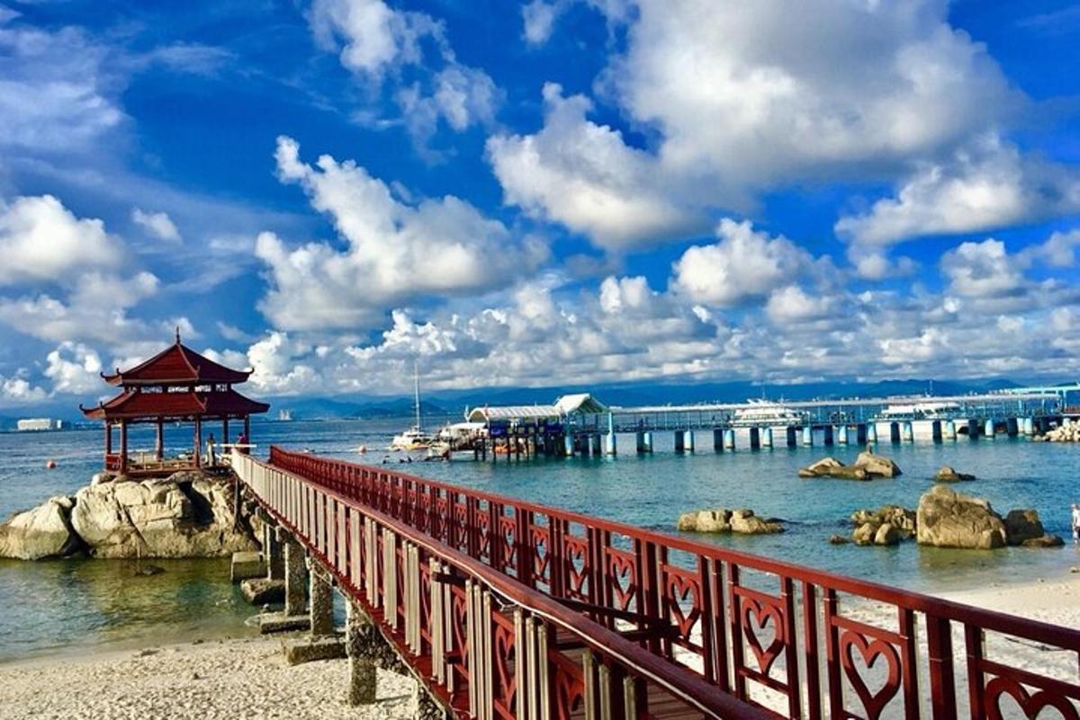 a red bridge over the water next to a pier