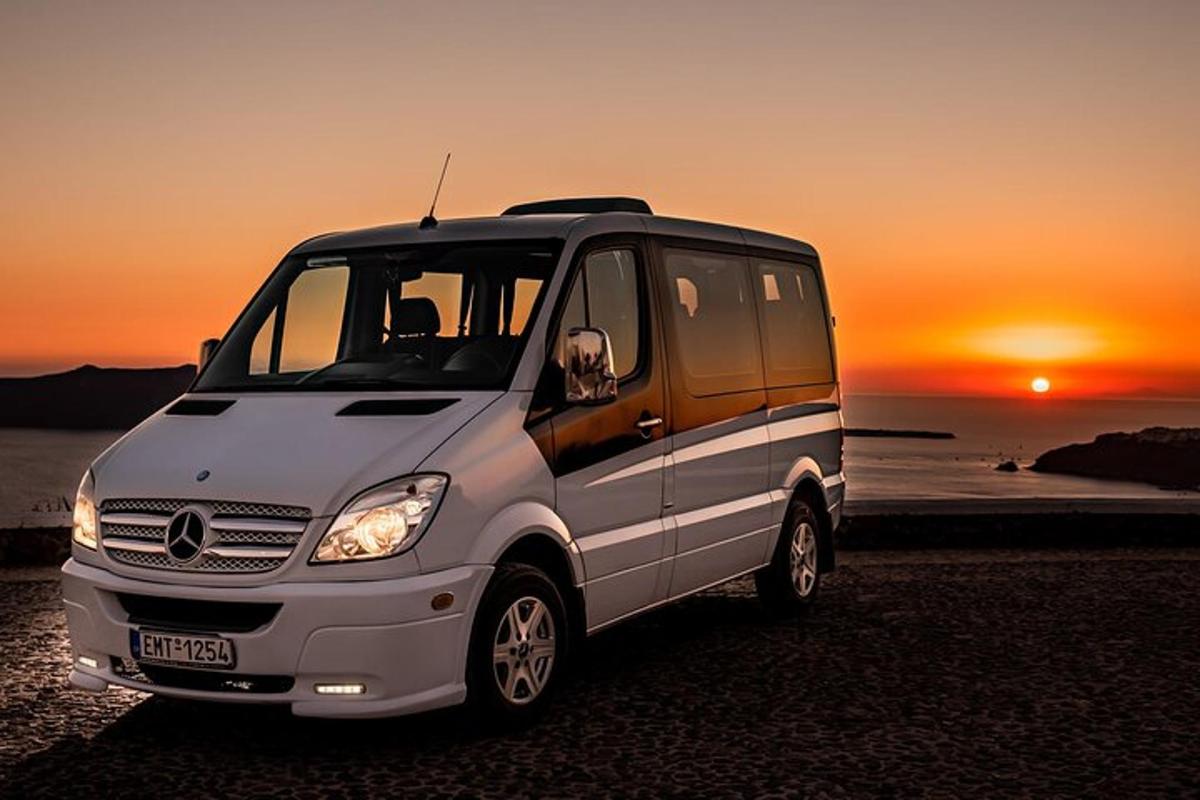 uma van estacionada na praia com o pôr do sol ao fundo