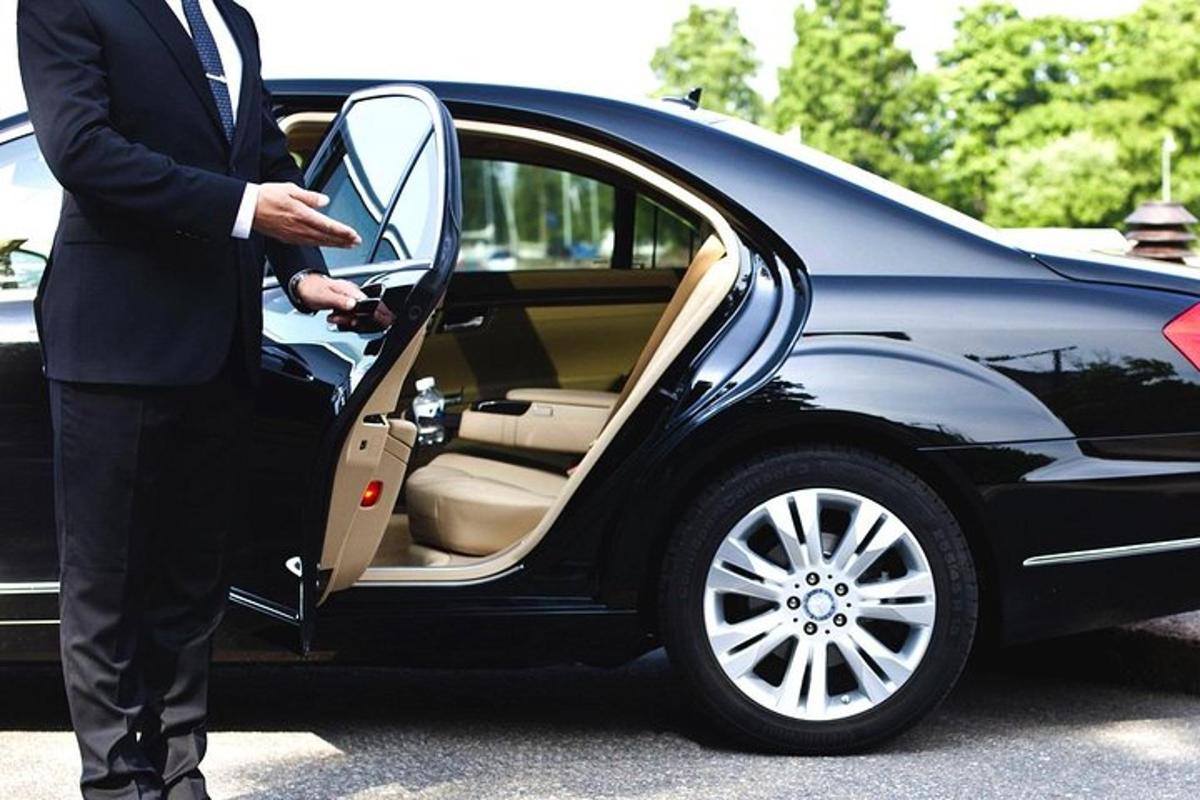 vyras su kostiumu lipa į automobilį
