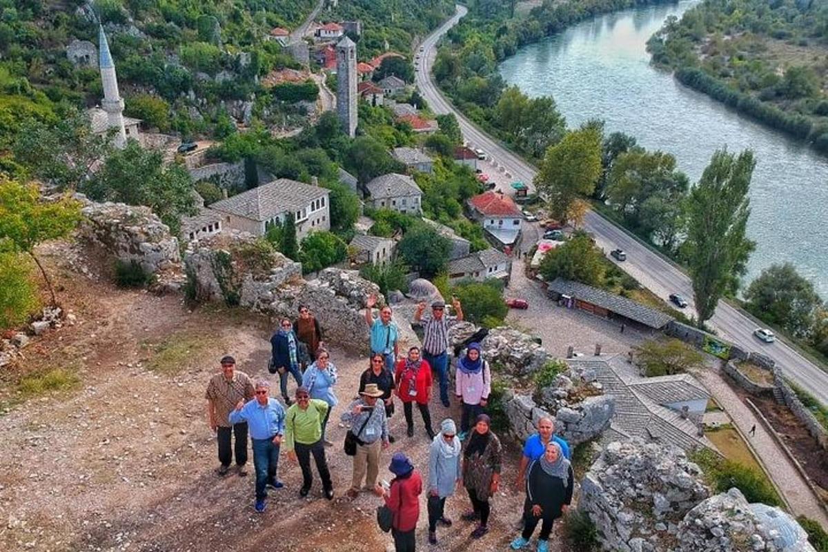 Un grupo de personas caminando por una colina cerca de un río.