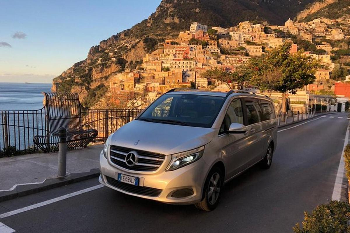 una furgoneta platejada aparcada en una carretera a prop de l'oceà