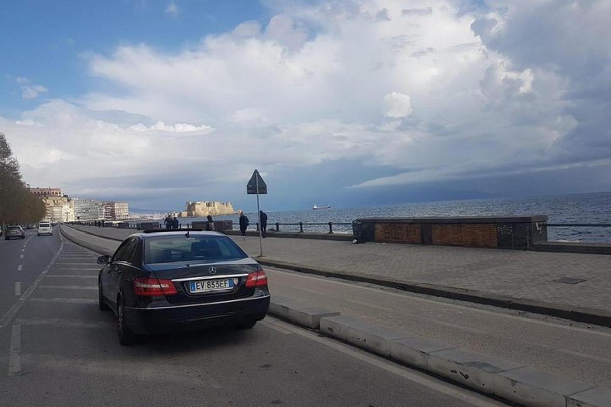 un'auto che percorre una strada vicino all'oceano