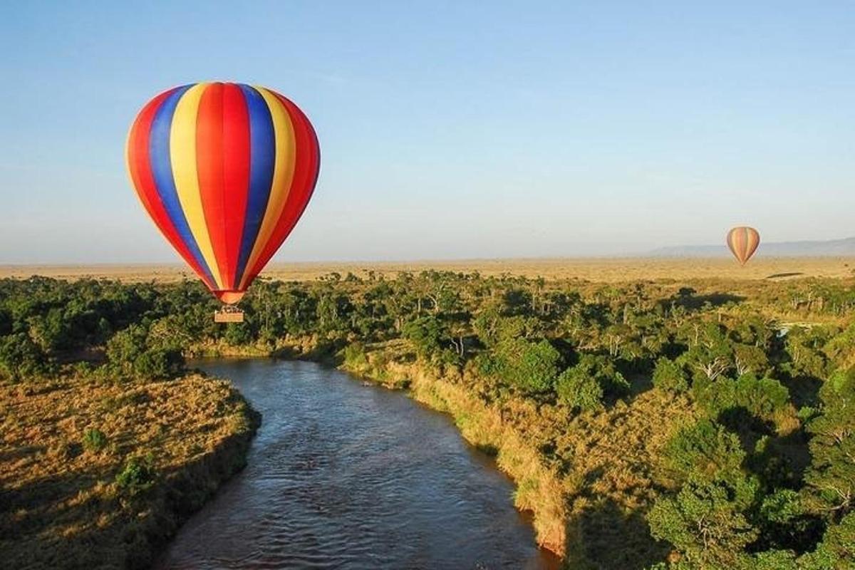 zwei Heißluftballons fliegen über einen Fluss