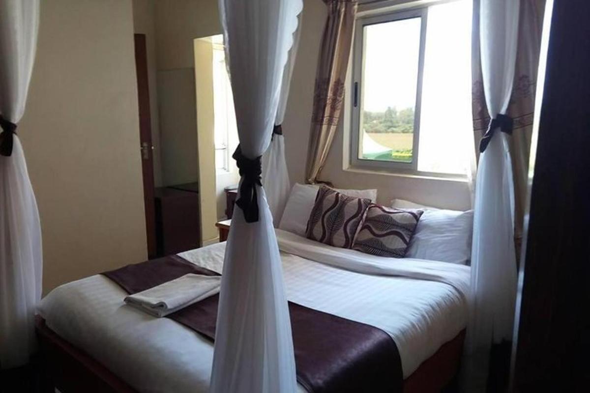 ein Schlafzimmer mit einem Bett mit Vorhängen und einem Fenster