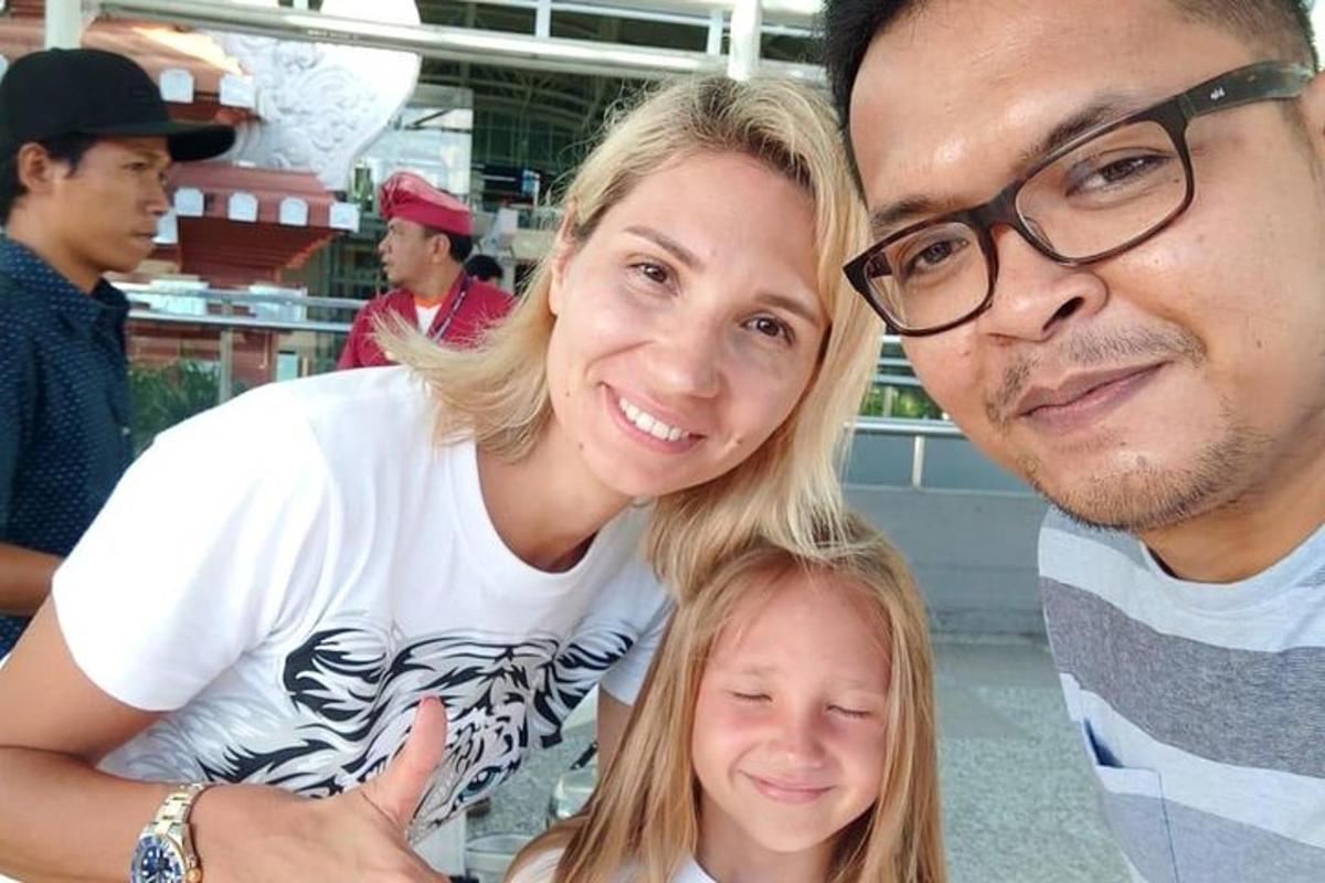 muž a žena pózují pro fotografii s malou holčičkou