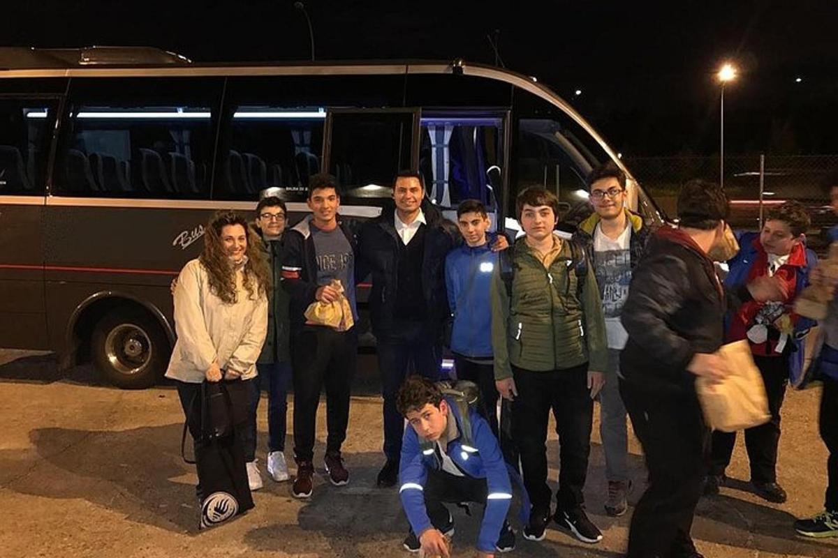 un grup de persones dretes davant d'un autobús