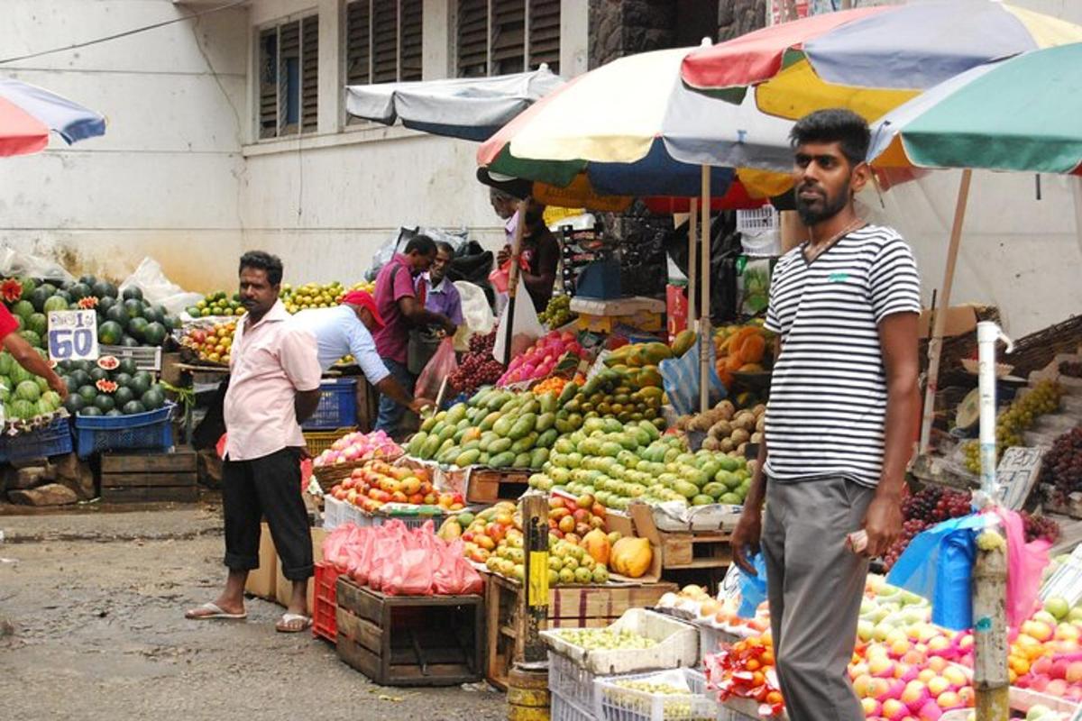 two men standing in an outdoor market with fruits and vegetables