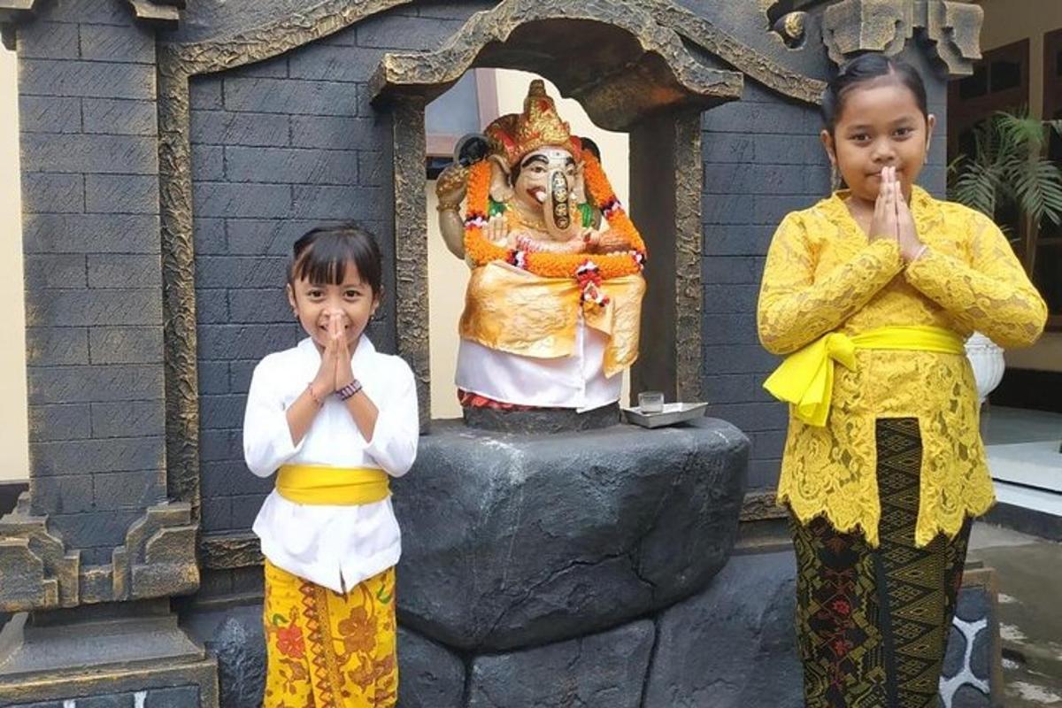 Dos niños de pie junto a una estatua de una mujer.