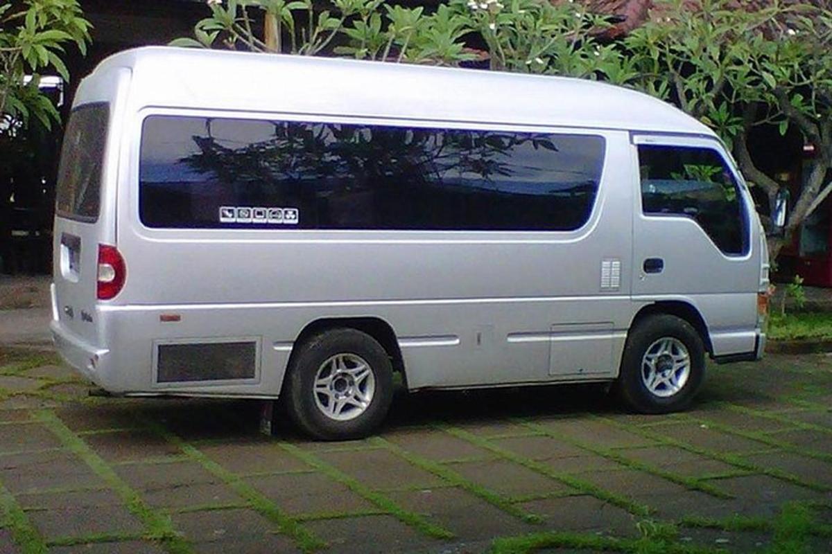 Una camioneta blanca está estacionada en una acera