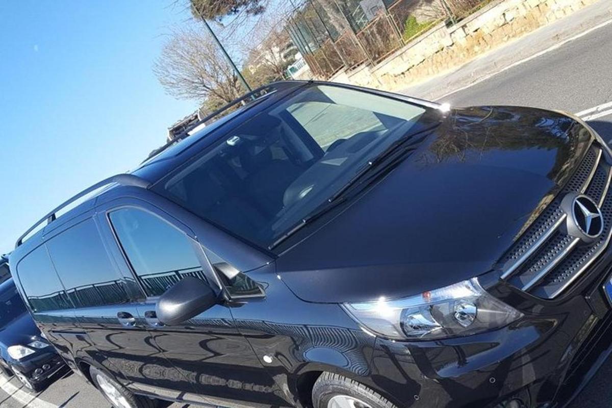 melna automašīna, kas novietota ielas malā