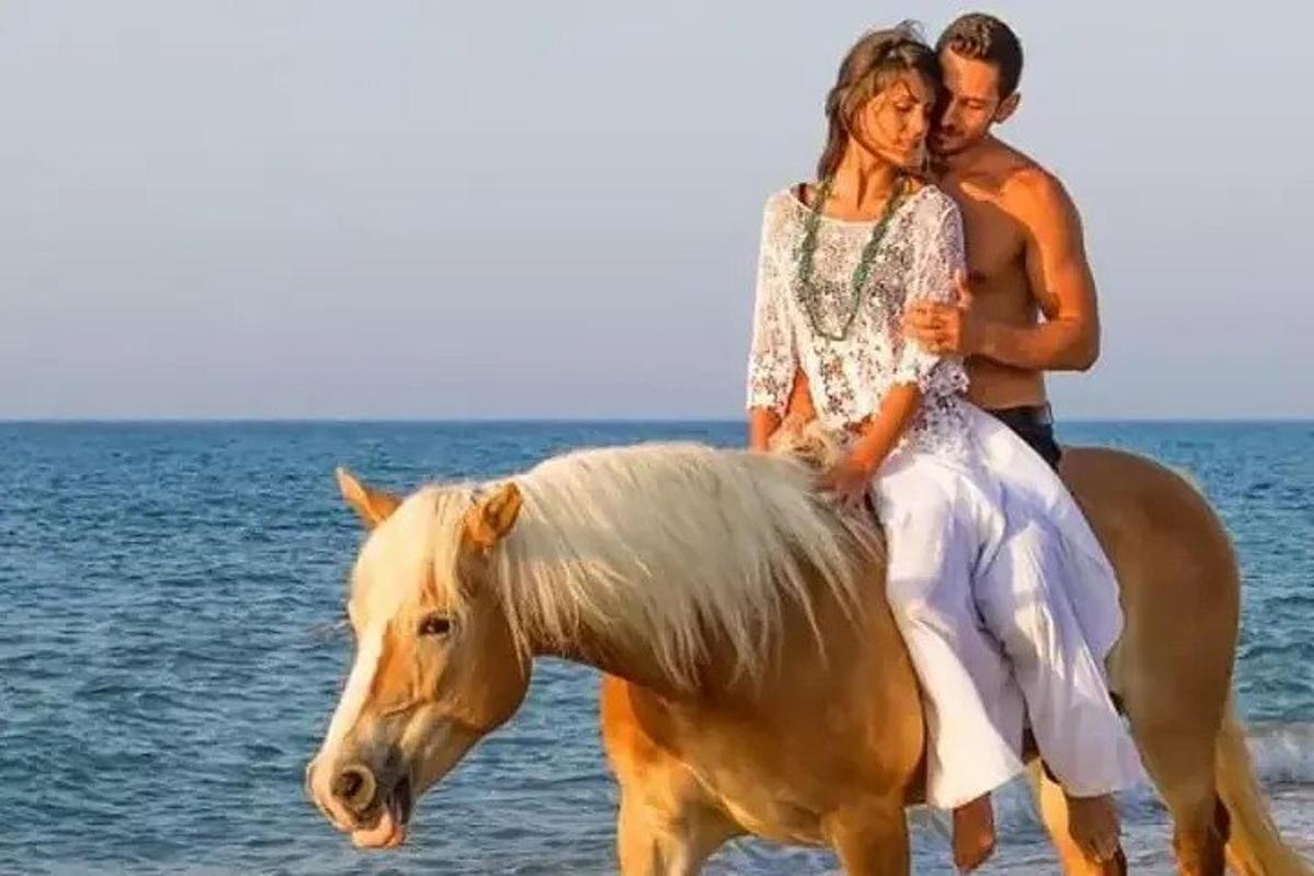 một người đàn ông và một người phụ nữ cưỡi ngựa trên bãi biển