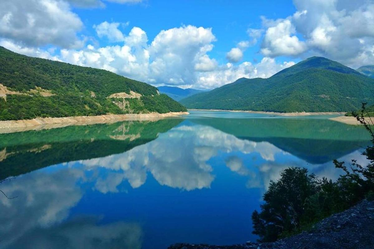 arka planda dağlar bulunan büyük bir su kütlesi