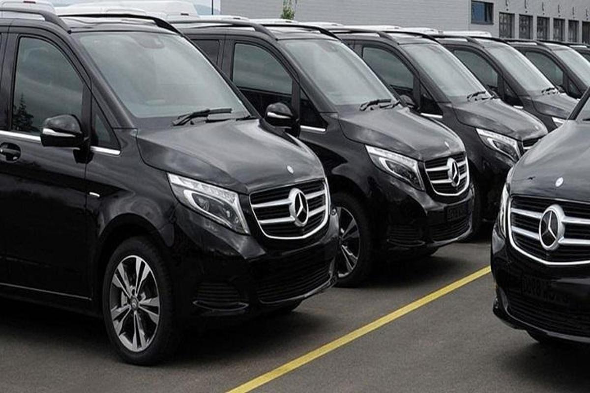 a row of black suvs parked in a parking lot