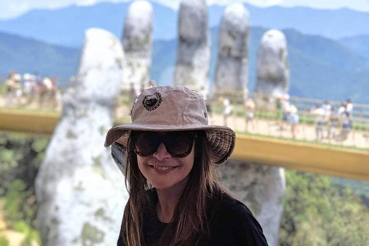 una donna che indossa un cappello in cima a una montagna