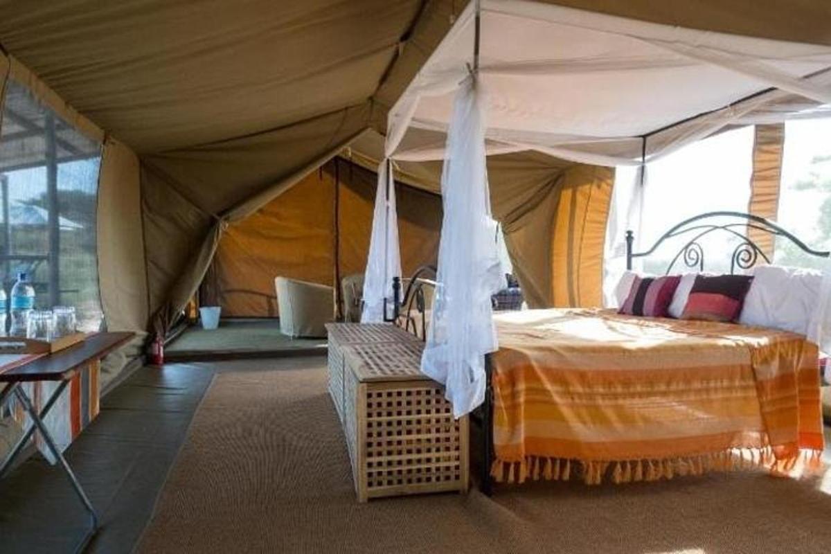 una camera da letto con una tenda con un letto e una panca