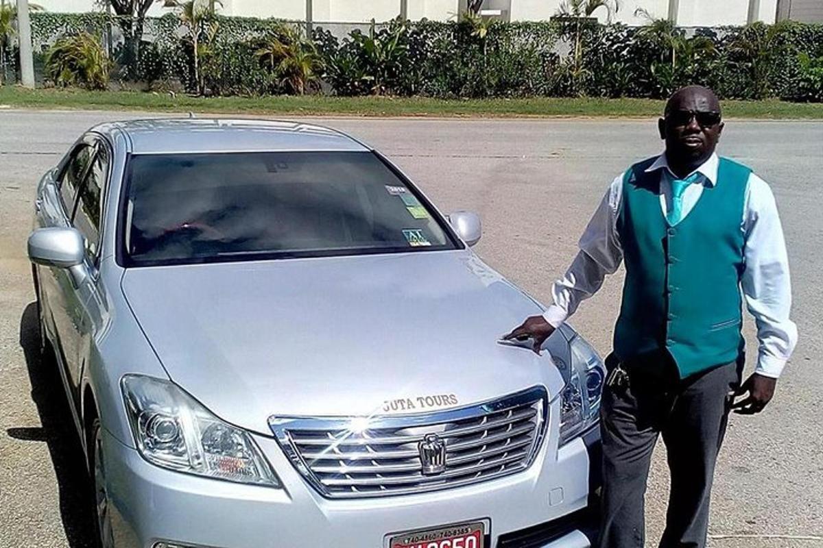 un uomo in piedi accanto a un'auto argentata