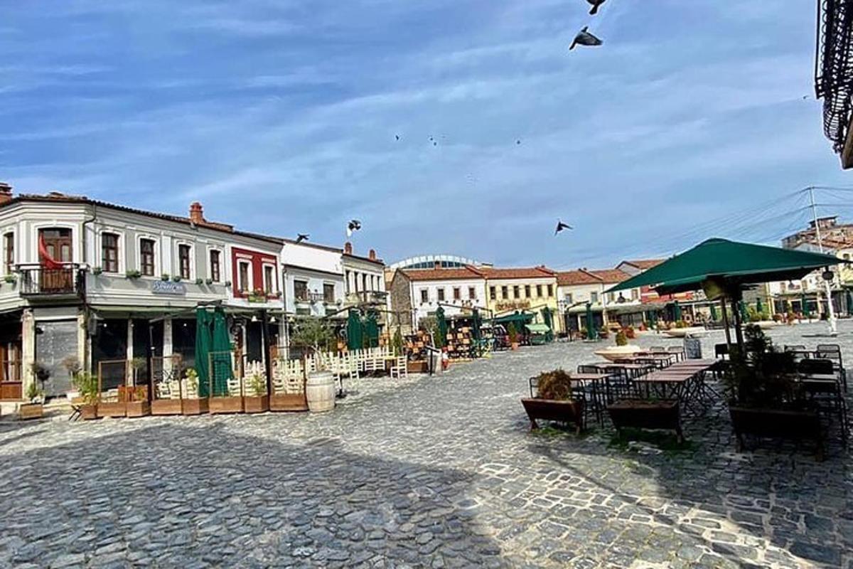 ένας δρόμος της πόλης με τραπέζια και καρέκλες και κτίρια