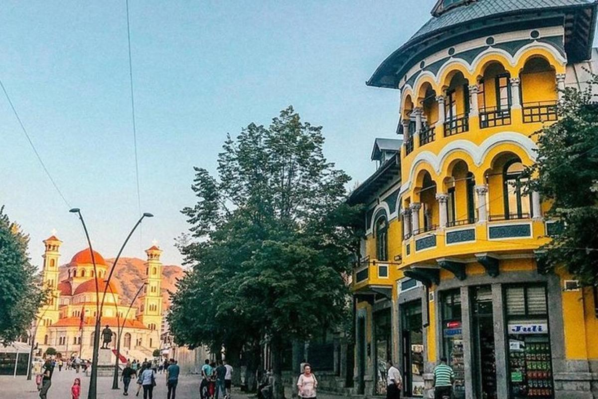 en gul byggnad med människor som går på en stadsgata