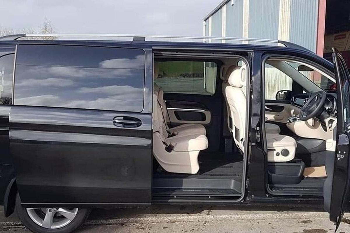 uma van preta com a porta aberta em um estacionamento