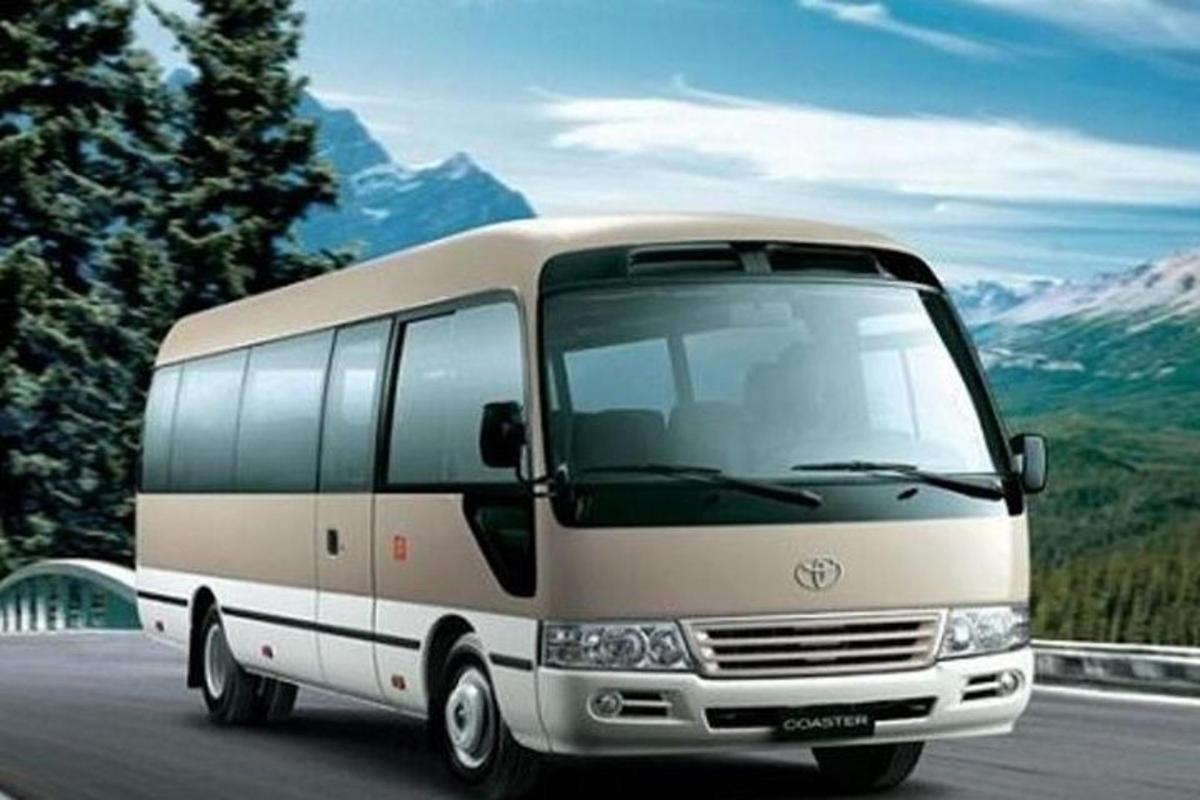 um ônibus branco dirigindo por uma estrada com montanhas