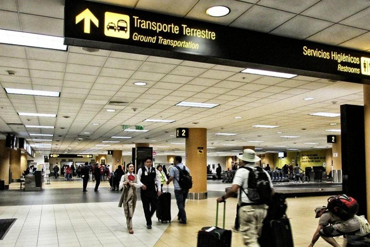un gruppo di persone che camminano in un aeroporto con i bagagli