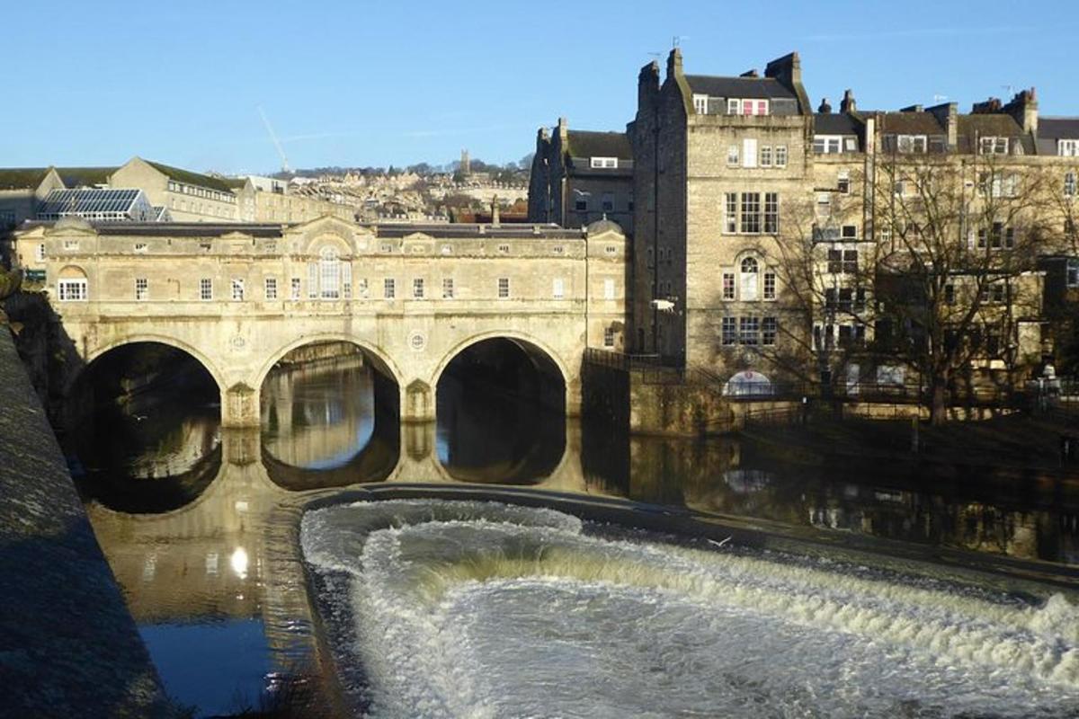 un ponte con una cascata di fronte a un edificio
