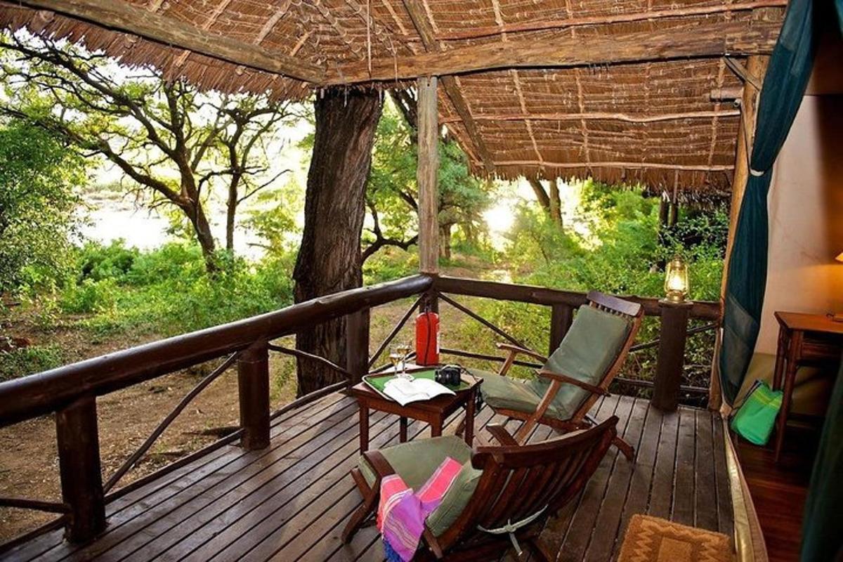 a porch with two chairs and a table on a deck