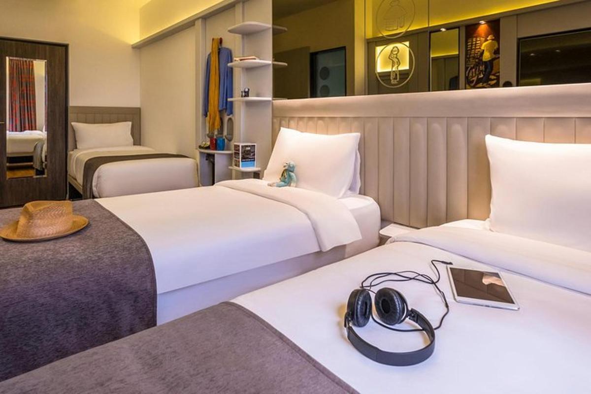 Una habitación de hotel con dos camas con sombreros.