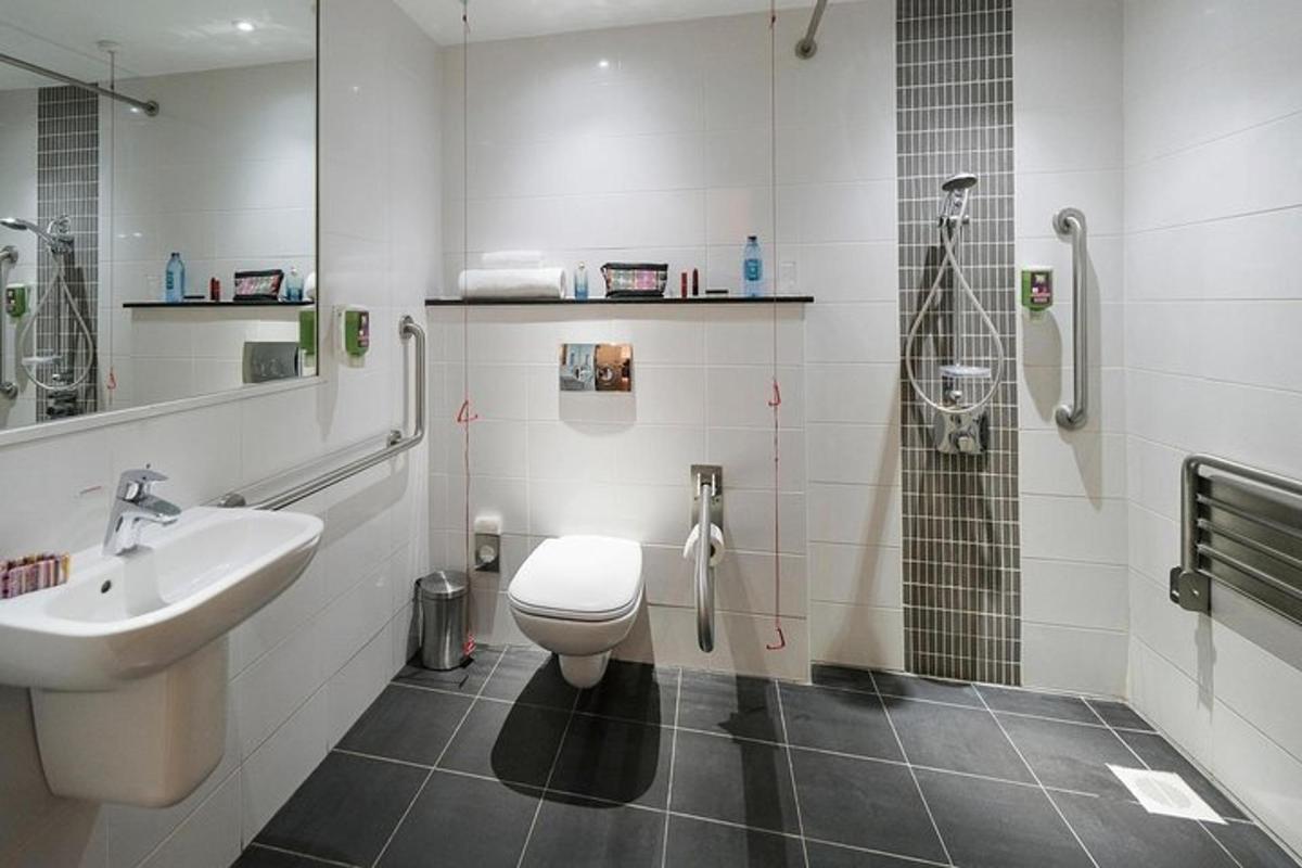 Un baño con inodoro, lavabo y ducha.