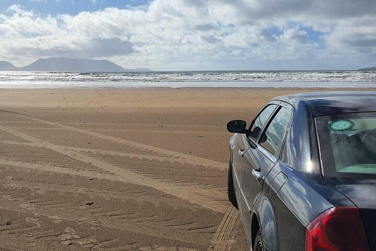 un'auto parcheggiata su una spiaggia vicino all'oceano