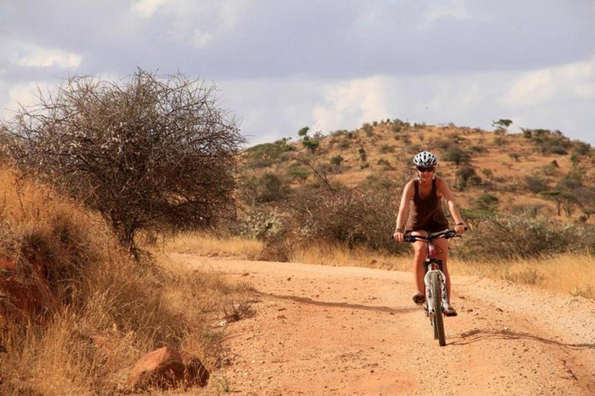 un hombre montando en bicicleta en un camino de tierra