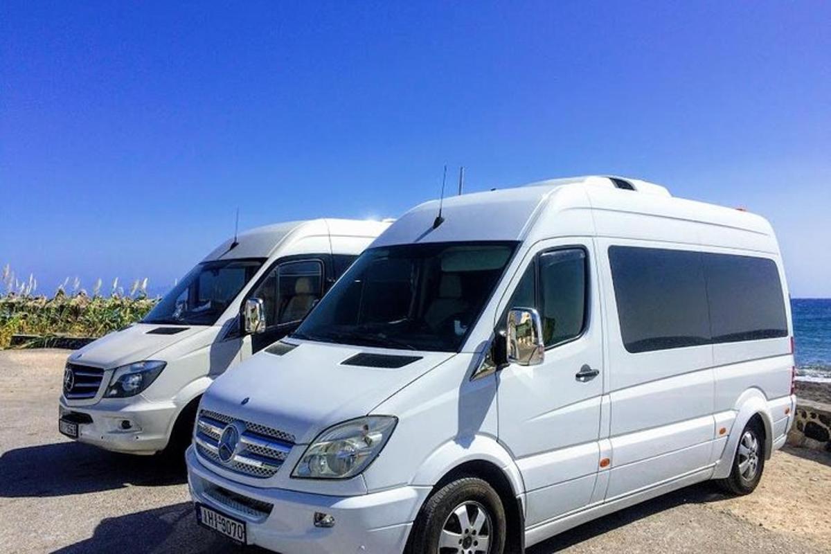 dua mobil van putih terparkir di samping laut