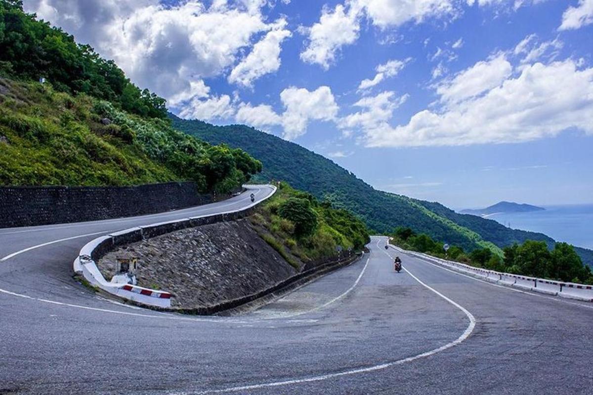 bir tepede motosiklet süren bir kişinin olduğu dolambaçlı bir yol