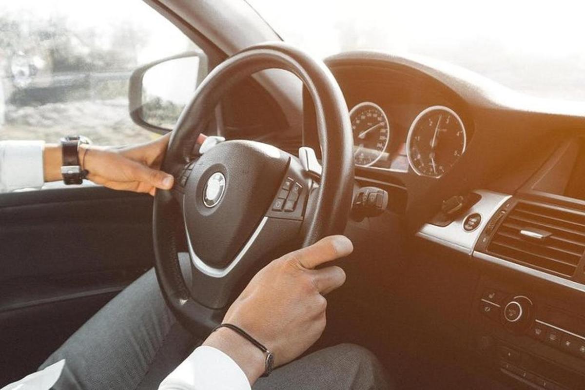 osoba řídící auto s volantem