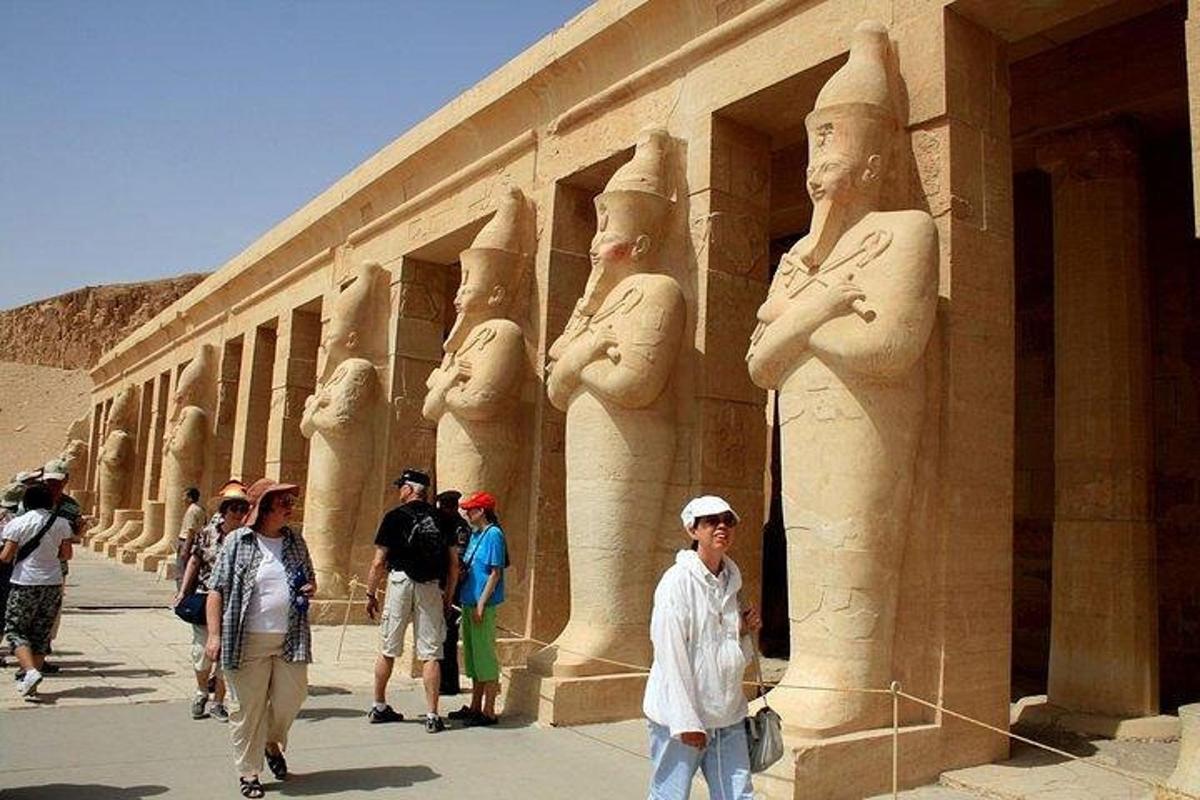un gruppo di persone in piedi davanti a un edificio con statue