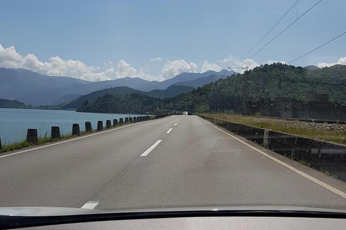 uma estrada com vista para um lago e montanhas