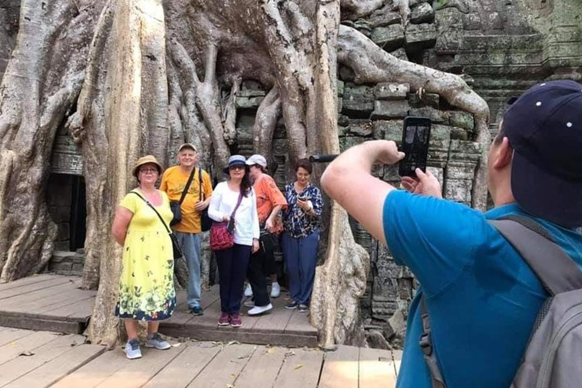 un uomo che scatta una foto a un gruppo di persone davanti a un albero