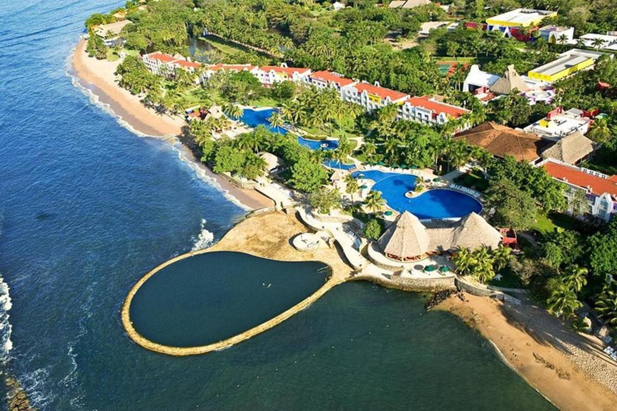 an aerial view of a resort next to the water