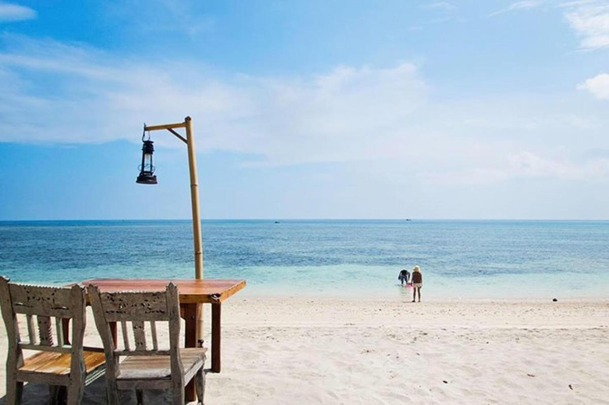 un tavolo e delle sedie su una spiaggia con l'oceano