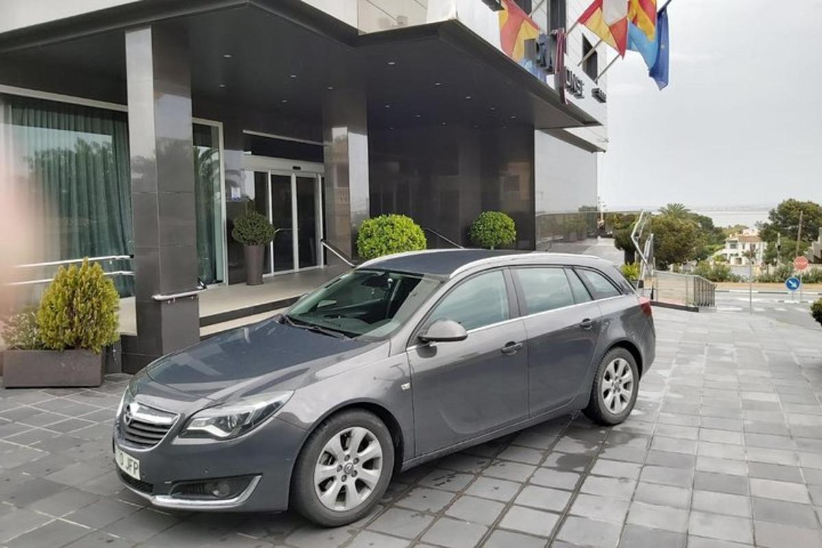 Un coche gris aparcado delante de un edificio.
