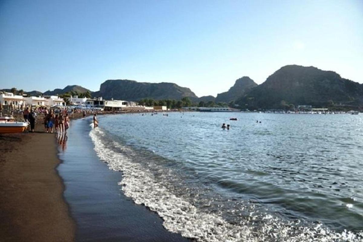 Μια ομάδα ανθρώπων που στέκονται σε μια παραλία κοντά στο νερό