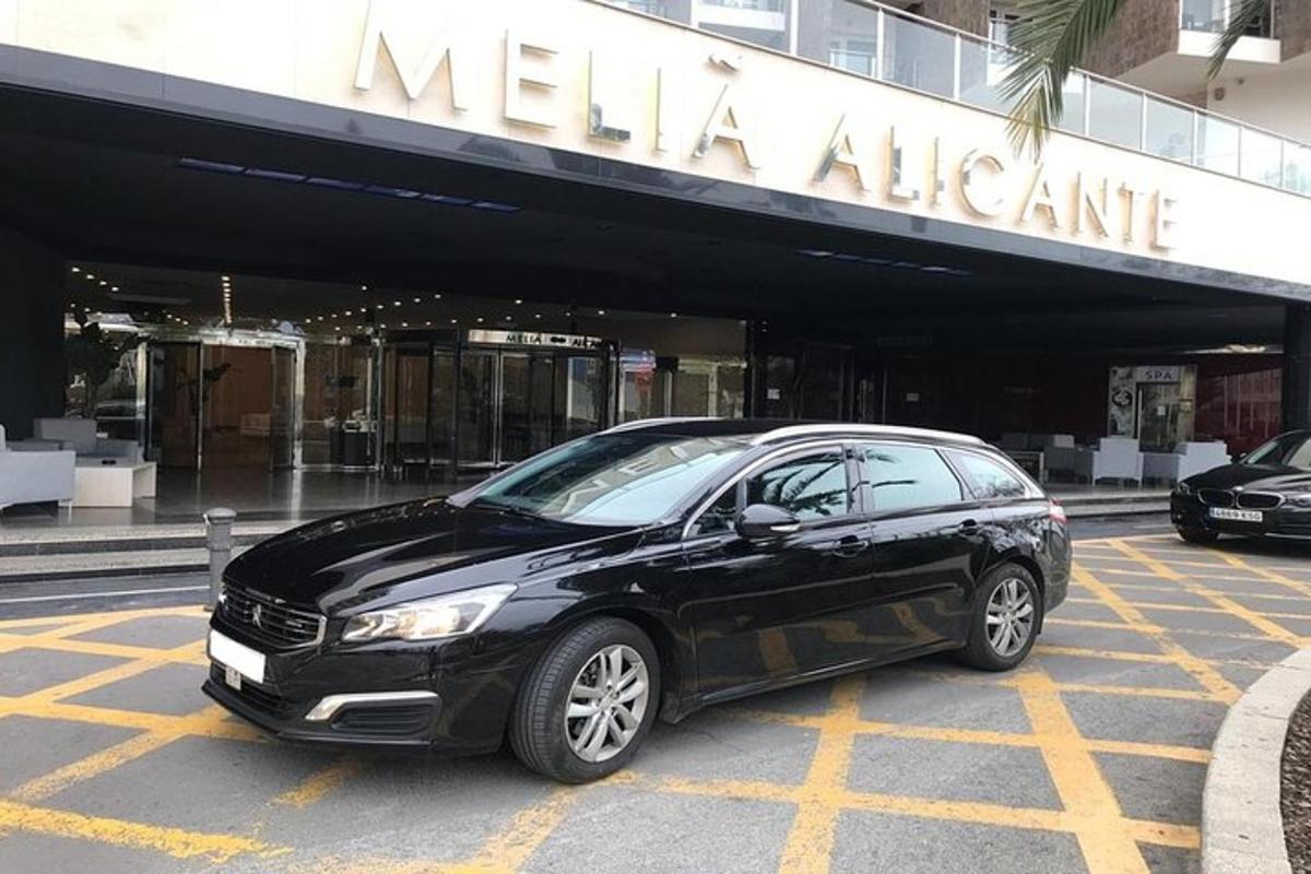 um carro preto estacionado em frente a um prédio